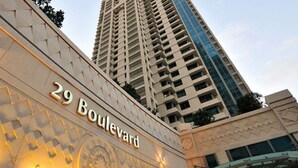 A building with the sign "29 Boulevard" and a tall adjacent skyscraper.