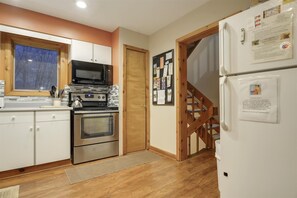 Compact kitchen with microwave, stove, and refrigerator, offering a convenient space for meal preparation.