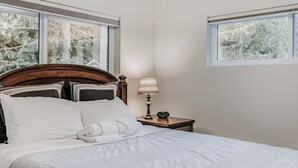 A neatly made bed with white linens, a wooden headboard, and a bedside table with a lamp and radio. - 47MF - WiFi - Fireplace - Sleeps 6 3 Bedroom Home by RedAwning (Maple Falls)