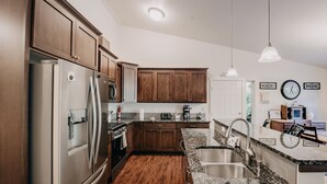 A modern kitchen with wooden cabinets, stainless steel appliances, granite countertops, and a built-in oven. - 47MF - WiFi - Fireplace - Sleeps 6 3 Bedroom Home by RedAwning (Maple Falls)