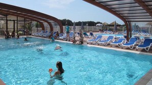 A swimming pool with lounge chairs and people swimming. - Lovely mobile home in a 4-star residential estate in Les Sables D'Olonne (Les Sables-d'Olonne)