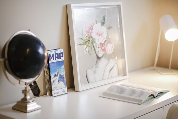 A desk with a globe, a framed picture, a book, and a lamp.