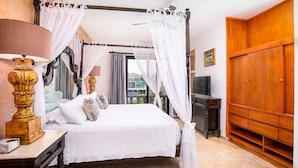 Una camera da letto con un letto a baldacchino, una televisione e un armadio in legno.