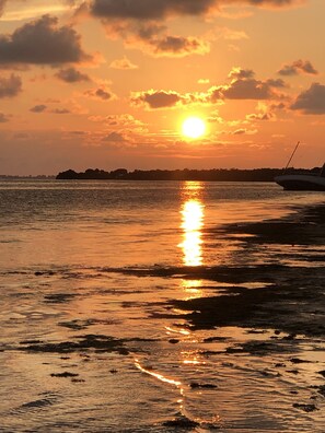 Ein Sonnenuntergang über ruhiger See mit einem Boot auf der rechten Seite.