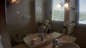 Un bagno con lavandino, specchio e finestra con persiane.