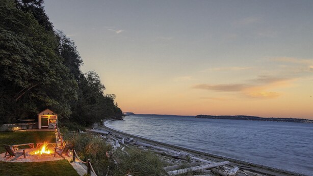 A beachside property with a fire pit, outdoor seating, and a small building with a door labeled "Guesthouse." - Ferry Cove - Private low bank beachfront property. (Clinton)