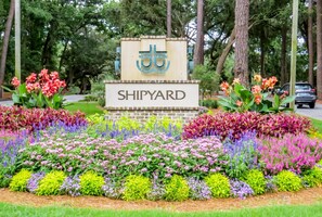 A sign with 'SHIPYARD' and a logo, surrounded by a colorful flower garden.