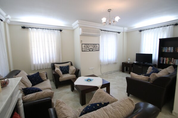 A living room with a sofa set, a coffee table, and a television.