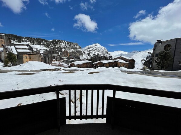 A snowy mountain village with wooden buildings and a clear blue sky.