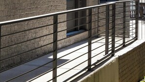 A modern building with a brick facade, large windows, and a metal balcony railing. - Charming Rustic Stay – Near Belmont (Nashville)