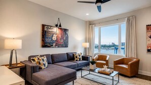 A modern living room with a sofa, armchairs, a coffee table, and a view of the water. - Rooftop Nashville Stay – Near Honky Tonks (Nashville)