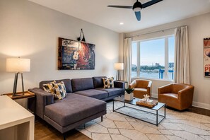 A modern living room with a sofa, armchairs, a coffee table, and a view of the water. - Rooftop Nashville Stay – Near Honky Tonks (Nashville)