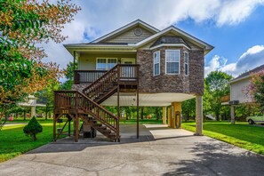 A two-story house with a stone facade, a covered porch, and a wooden staircase leading to the upper level. - CLOSE to the heart of Pigeon Forge w/flat,EZ parking, near the river & free Wifi (Pigeon Forge)