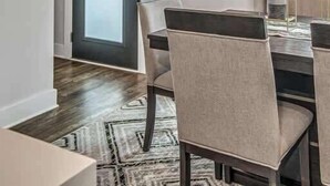A dining area with a table set for four, a modern pendant light, and a view through a door to the outside. - Nashville Cowgirl Stay – Rooftop Views (Nashville)