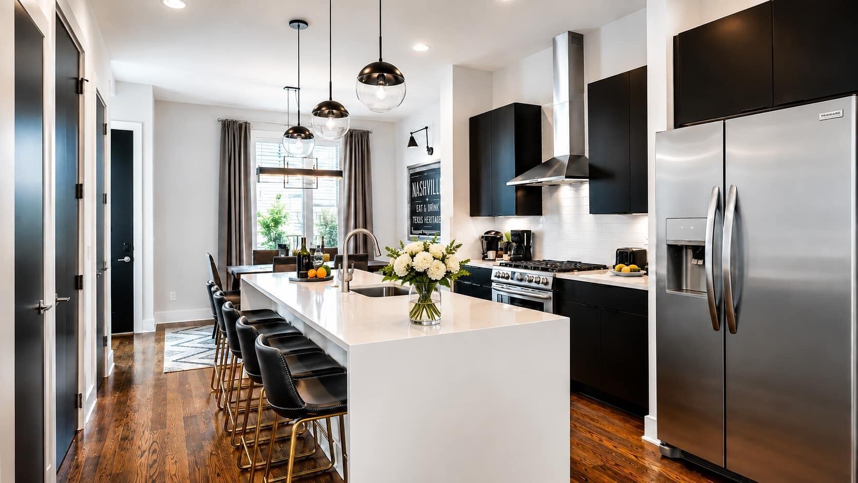 A modern kitchen with a central island, stainless steel appliances, and a bar area with stools.