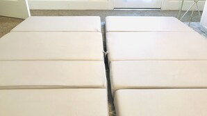 Cuatro bancos rectangulares color beige, acolchados y dispuestos en fila.