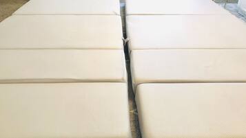 A set of four beige, rectangular, padded benches arranged in a row.