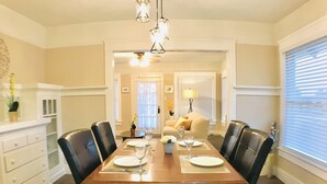 Comedor con una mesa de madera dispuesta para seis personas, rodeado de sillas negras.