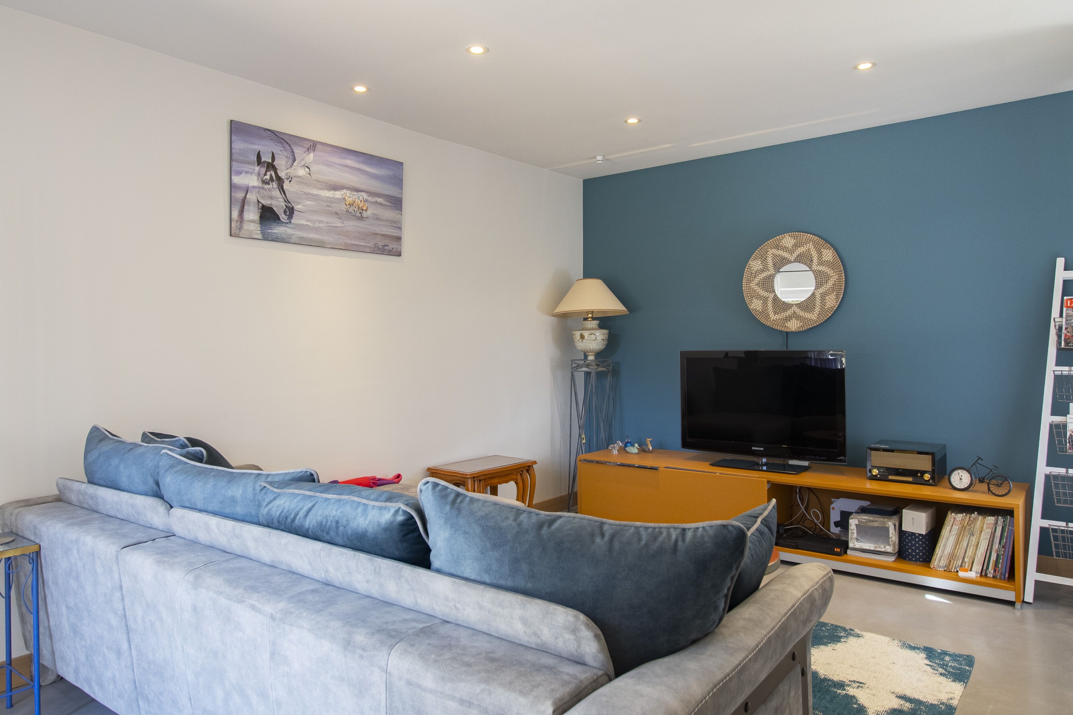 A living room with a sofa, a television, and a bookshelf.