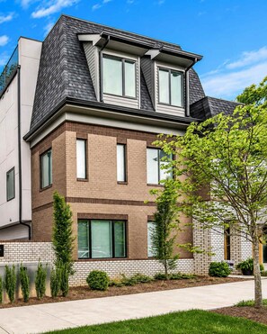 A modern two-story house with a brick facade, large windows, and a sloped roof. - Scovel Row Stay • Rooftop • Near Broadway (Nashville)