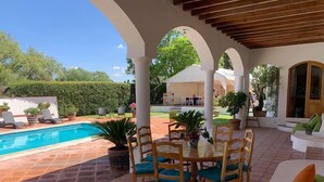 A covered outdoor area with a pool, seating, and potted plants. - La Casona de los Colibríes (Corregidora)