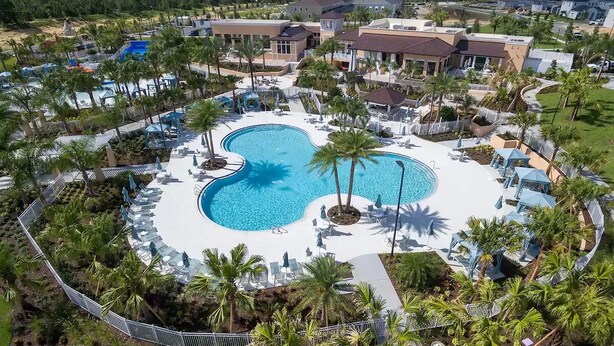 A resort with a large central pool, surrounded by palm trees and lounge chairs. - Late Summer at Solara • Private Pool• Walk To Clubhouse (Kissimmee)