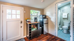 A compact kitchen with a refrigerator, microwave, and coffee maker on a small countertop. - Tiny house in Bishop Arts! (Dallas)