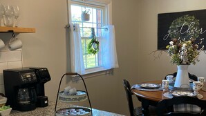 A kitchen with granite countertops, a coffee maker, a tea kettle, and a dining area with a table set for four. - “Granite Getaway Cottage.”  An adorable cottage in a quiet family neighborhood (Granite Falls)