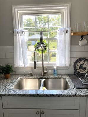 Enjoy cooking in this well-equipped kitchen with a stainless steel sink, modern faucet, and granite countertop.