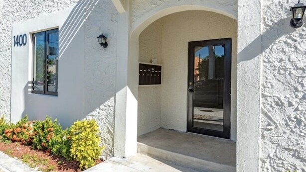 A white building with a black door and a mailbox. - Stylish 1 Brm Apartment in the Heart of Miami! #9 (Miami)