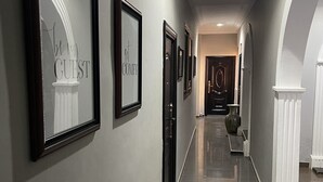 Um corredor com quadros que dizem 'seja nosso convidado' e 'conforto'.