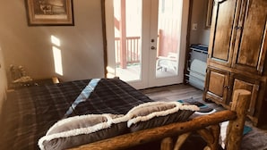 Une pièce comprenant un lit, une armoire en bois et un téléviseur.