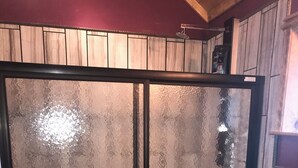 Een badkamer met een douchecabine van glas, toilet en wastafel.