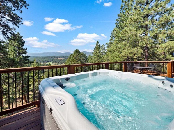 A hot tub on a wooden deck with a view of a forest and mountains. - Valley View Cabin, New Hot Tub, Close to Ski Lifts! (Angel Fire)