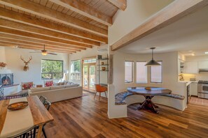 A spacious living area with a wooden ceiling, a dining table, a sofa, and a built-in bench. - Spacious and Contemporary, Huge Primary Suite (Santa Fe)