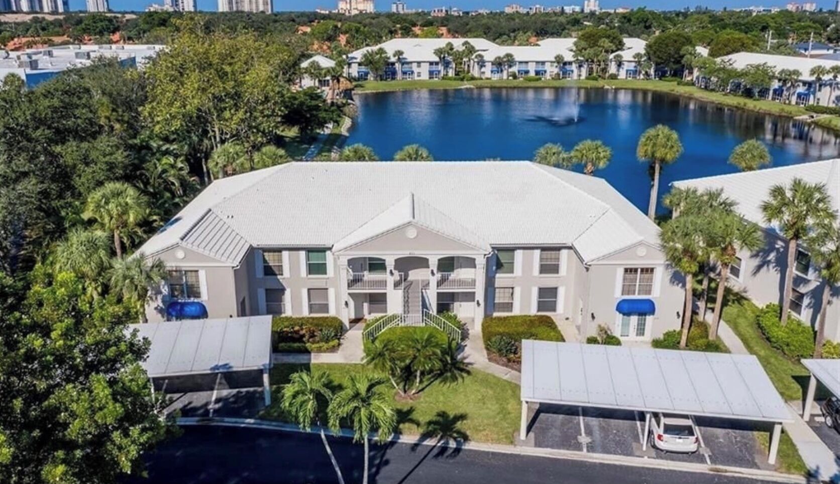 A large, multi-story hotel with a central courtyard and a swimming pool.