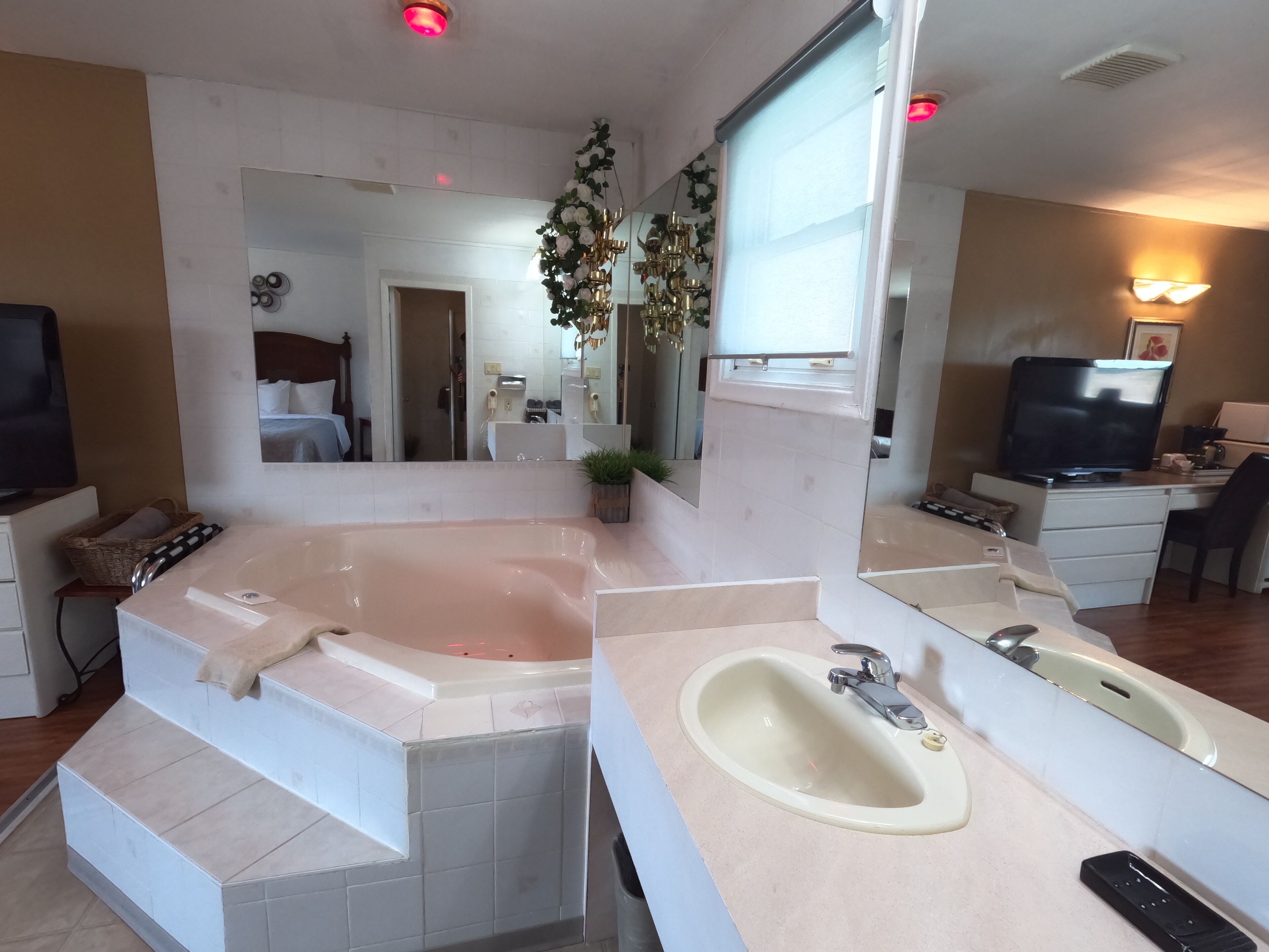 A modern bathroom with a large bathtub, a vanity with a sink, and a large mirror.