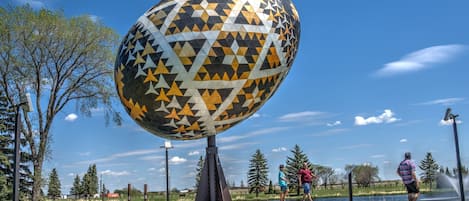Una escultura esférica con un diseño geométrico en un parque.