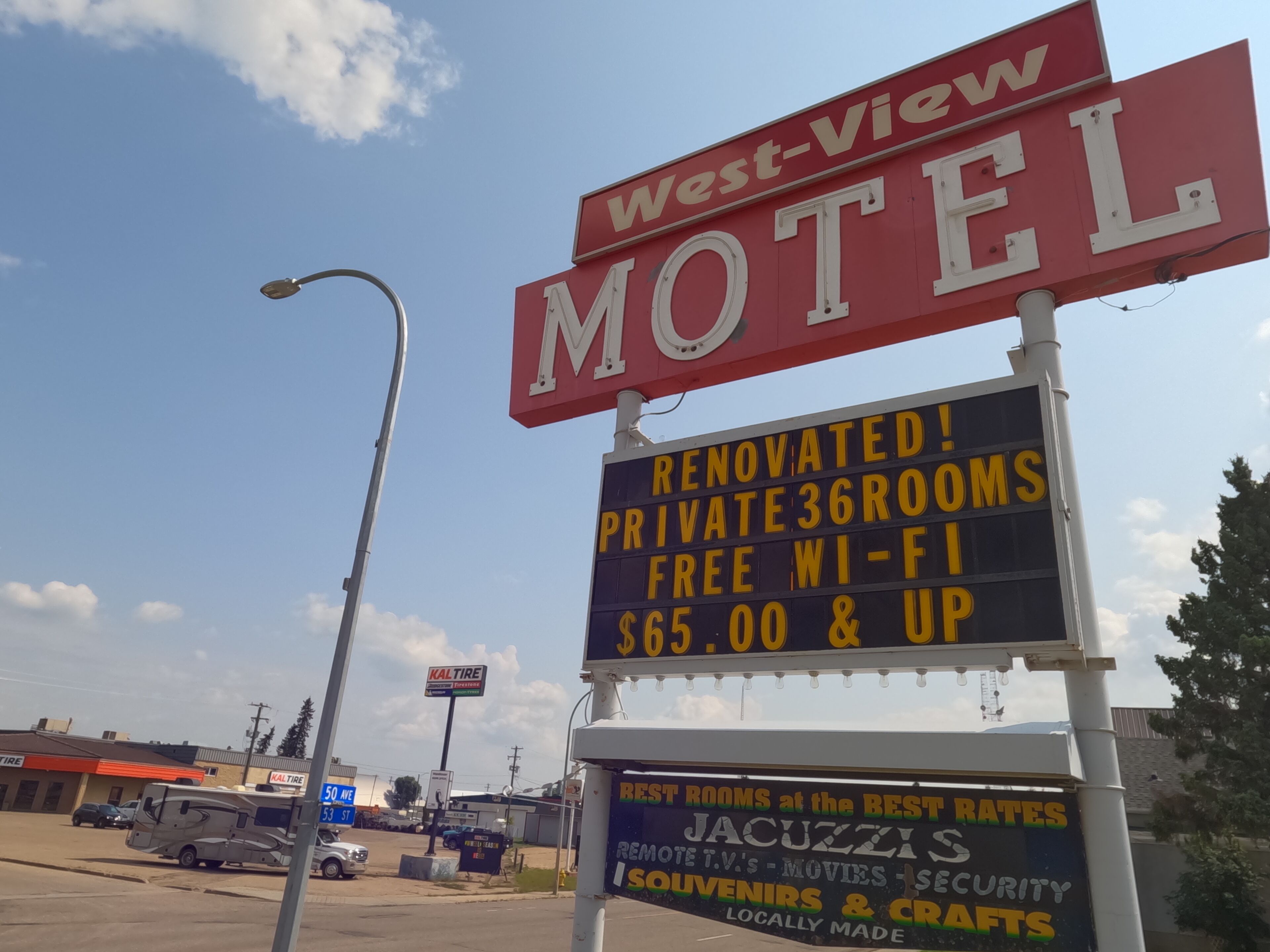 A motel sign with 'West-View Motel' and 'Renovated! Private 36 rooms, Free Wi-Fi, $65.00 & up'.
