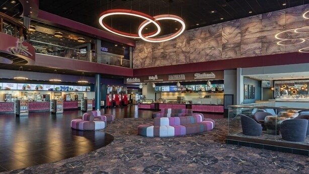 Een ruime lobby met een centrale zithoek, een foodcourt en een bar.