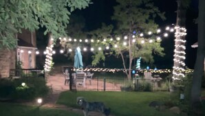A nighttime outdoor area with string lights, a pathway, and a dog. -  Mt. Vernon Ranch House near Red Rocks and Colorado Mountains, skiing. Est 1860 (Golden)