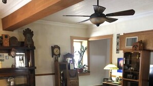 A cozy living room with a fireplace, wooden furniture, and a ceiling fan. -  Mt. Vernon Ranch House near Red Rocks and Colorado Mountains, skiing. Est 1860 (Golden)
