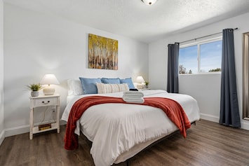 Luxurious King Bed (Bedroom 1) with reading lamps and blackout curtains.