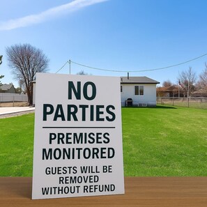 A sign indicating no parties allowed, premises monitored, and guests removed without refund.