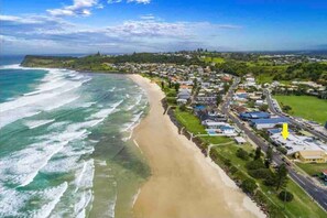 A coastal town with a beach, houses, and a road. - Lennox Head Waves Beachfront Penthouse (Lennox Head)