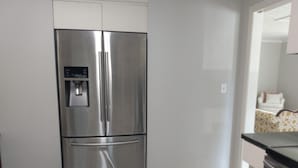 A stainless steel refrigerator in a kitchen with a grey tiled floor and white walls. - Family Friendly Fully Renovated Quiet House  (Dresden)