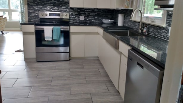 A modern kitchen with stainless steel appliances, a black backsplash, and light-colored cabinetry. - Family Friendly Fully Renovated Quiet House  (Dresden)