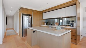 Uma cozinha moderna com uma ilha central, eletrodomésticos de aço inoxidável e armários de madeira.
