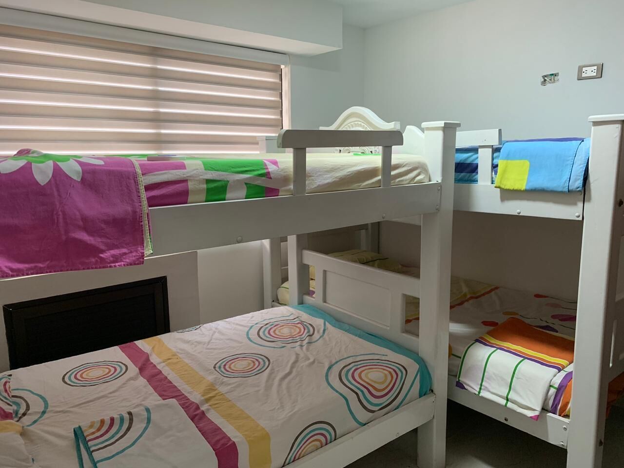 Dormitorio con literas, ventana, escritorio y una silla.