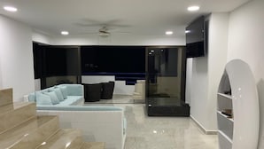 Un soggiorno moderno con un divano, un tavolino e una TV a parete.